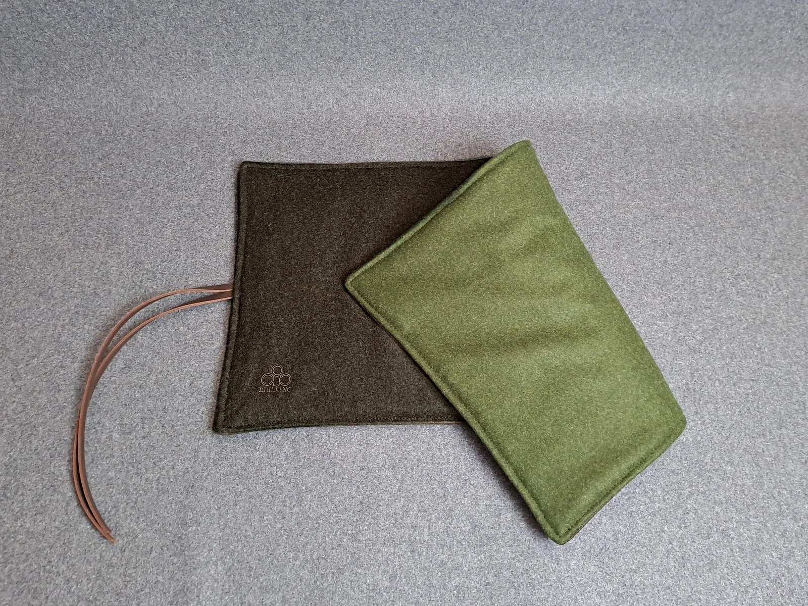 Loden-Sitzkissen mit brauner Oberseite und grüner Rückseite im direkten Vergleich.