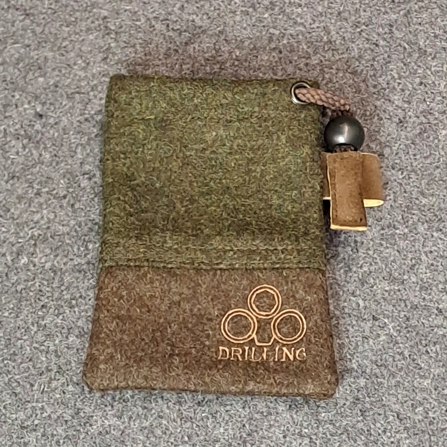 Kleiner DRILLING Lodenbeutel mit sichtbarem Kordelstopper, Lederlasche und Logo.